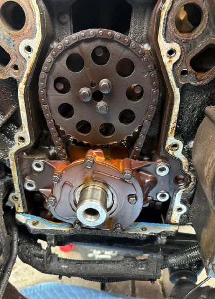 Engine with the front cover removed showing the timing chain and oil pump